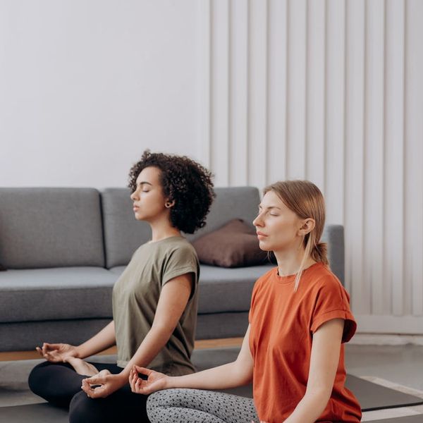 Woman in a calm, balanced pose in a bright, modern living room.